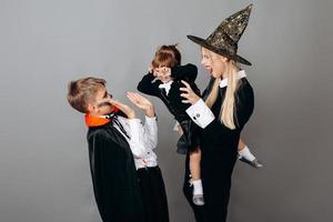 família em trajes extravagantes, mostrando um gesto assustador. - conceito de halloween foto
