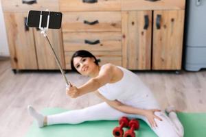 uma garota tira uma selfie sentada em uma corda no tapete foto