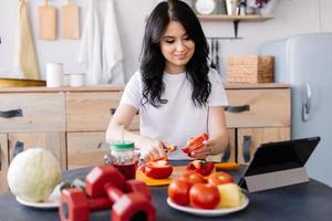 jovem, desportiva e bem cuidada, prepara comida útil após o treino foto