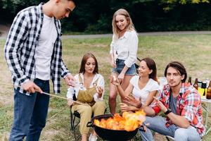 amigos no acampamento cozinhando comida grelhada foto