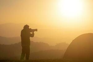 fotógrafo é levando panorama foto de a barraca durante durante a noite acampamento às a lindo cênico nascer do sol sobre a montanha para ao ar livre aventura período de férias viagem conceito