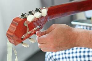 fechar-se do uma do homem mãos afinação uma guitarra. foto