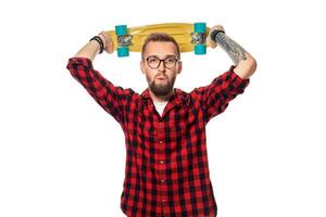 hipster homem sobre branco fundo segurando amarelo skate. ativo cara dentro xadrez camisa com cópia de espaço foto