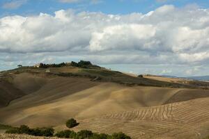 colhido Campos e prados panorama dentro toscana, Itália. ondulado país cenário às outono pôr do sol. arável terra pronto para a agrícola temporada. foto