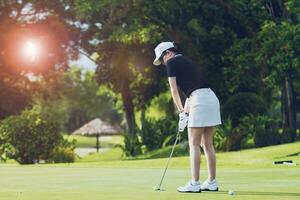 mulher colocando golfe em verde foto