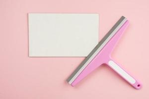 escova de janela deitada na maquete branca vazia sobre fundo rosa. serviço de limpeza de conceito foto
