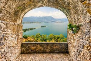 Rocha sacada negligenciar lago guarda, Itália foto