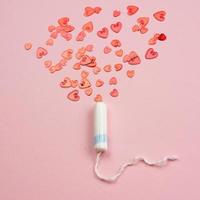 tampão feminino médico em um fundo rosa. tampão branco higiênico para mulheres. Cotonete. menstruação, meio de proteção. foto