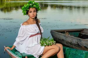 jovem sexy mulher em barco às pôr do sol. a menina tem uma flor guirlanda em dela cabeça, relaxante e Navegando em rio. fantasia arte fotografia. foto