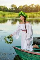 jovem sexy mulher em barco às pôr do sol. a menina tem uma flor guirlanda em dela cabeça, relaxante e Navegando em rio. fantasia arte fotografia. foto