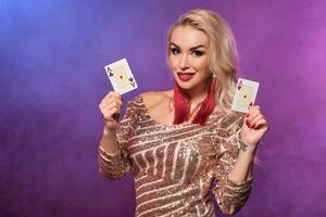Loiras mulher com uma perfeito Penteado e brilhante Maquiagem é posando com jogando cartões dentro dela mãos. cassino, pôquer. foto