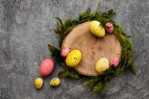 coloridos, ovos de páscoa em um suporte de madeira no fundo rosa foto