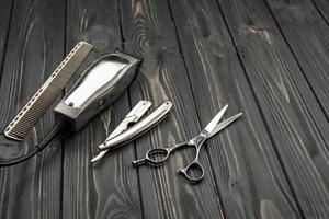 ferramentas de corte de cabelo masculino em um fundo escuro de madeira. foto