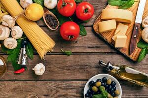 italiano Comida cozinhar-tomates, manjericão, massa, Oliva óleo e queijo em de madeira fundo, topo visualizar, cópia de espaço. foto