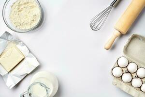 preparação do a massa. ingredientes para a massa - farinha, manteiga, ovos e vários ferramentas. em branco fundo. livre espaço para texto . topo Visão foto