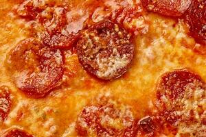 fechar-se do bronzeado derretido mozzarella queijo em cozido calabresa pizza foto