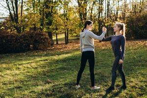 fitness ao ar livre, duas meninas de mãos dadas, cara a cara. foto