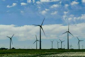 uma grupo do vento turbinas dentro uma campo foto