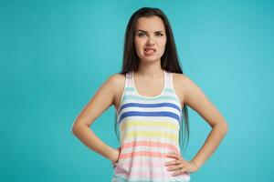 morena mulher com grandes cabelo, vestido dentro colorida listrado camisa, posando contra azul estúdio fundo. sincero emoções. fechar-se. foto