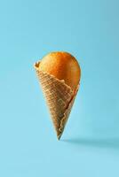 laranja gostar gelo creme mentiras dentro waffle cone em uma luz azul fundo. padronizar foto