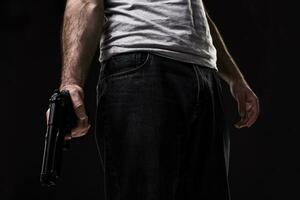 assassino com arma de fogo em Preto fundo às a estúdio foto