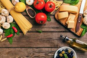 italiano Comida cozinhar-tomates, manjericão, massa, Oliva óleo e queijo em de madeira fundo, topo visualizar, cópia de espaço. foto