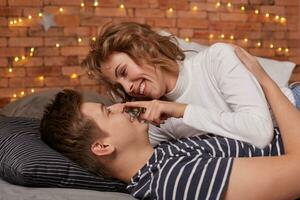 caucasiano jovem lindo casal mentira em cama e abraçando cada de outros foto