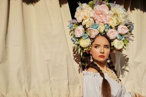 morena menina dentro uma branco ucraniano autêntico nacional traje e uma guirlanda do flores é posando contra uma terraço. fechar-se. foto