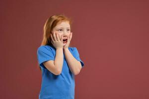retrato do fofa ruiva emocional pequeno menina em vermelho fundo foto