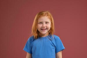 retrato do fofa ruiva emocional pequeno menina em vermelho fundo foto