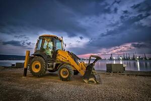 surpreendente Visão às amarelo escavadora com uma pá às uma construção local dentro uma lindo crepúsculo foto