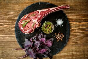 seco envelhecido cru tomahawk carne bife com ingredientes para grelhar foto