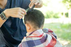 barbeiro corte cabelo do a ásia Garoto dentro a aberto espaço preenchidas com árvores foto