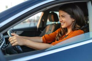 feliz mulher dirigindo uma carro e sorridente. fofa jovem sucesso feliz morena mulher é dirigindo uma carro. retrato do feliz fêmea motorista direção carro com segurança cinto foto