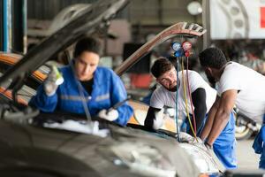 carro mecânico trabalhando dentro a auto reparar comprar, inspecionando a Operação do a carro de ar condicionador e refrigerante, foco em mulher foto