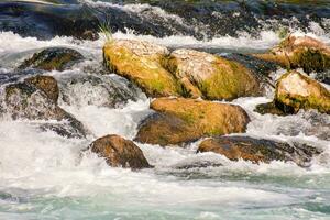 uma rio com pedras e água fluindo sobre eles foto
