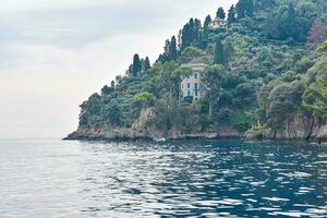 iate e barco em a mar e lindo velho villa em a penhasco dentro portofino, Itália. foto