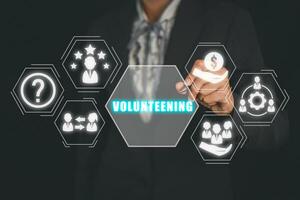 voluntariado conceito, empresária mão tocante voluntariado ícone em virtual tela. foto