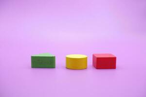 conjunto do colorida de madeira forma brinquedo. quadrado, triângulo e volta em roxa fundo foto