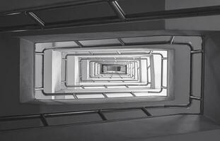 abstrato padronizar a partir de inferior Visão do temperamental escada dentro do construção dentro Sombrio tom estilo foto