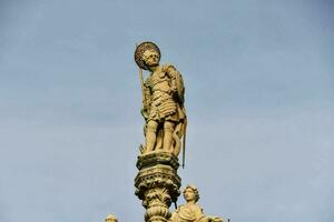 estátua do pessoa em topo do uma construção foto