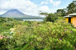 a casa é cercado de exuberante verde vegetação e uma montanha foto