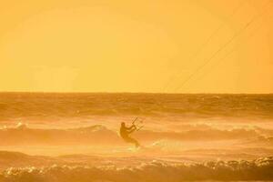 uma homem pipa embarque dentro a oceano às pôr do sol foto