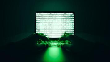 close up de hacker está usando o computador laptop para codificação de vírus ou malware para hackear servidor de internet, ataque cibernético, quebra de sistema, conceito de crime de internet.
