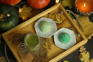 colorida japonês doces Daifuku ou mochi fatiado. doces fechar acima em a prato com copo do matcha chá foto