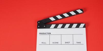 claquete ou filme. ele usa na produção de vídeo, cinema, indústria do cinema em fundo vermelho.