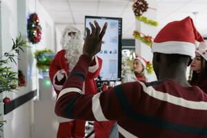 qualificado indústria alto falante vestido Como santa claus para Natal especial ocasião evento dentro festivo ornamentado sala de reuniões durante inverno feriado temporada. africano americano participante inquirindo sobre o negócio idéia foto