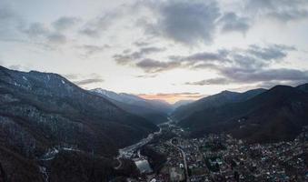 vista aérea de krasnaya polyana no pôr do sol, montanhas cobertas pela neve. Rússia. foto