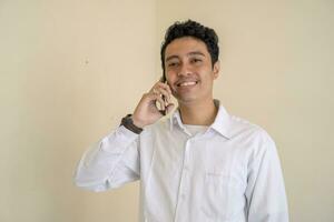 indonésio escritório empregado vestem branco roupas feliz quando chamando. foto