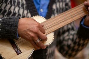 peruano jogando uma miniatura guitarra foto
